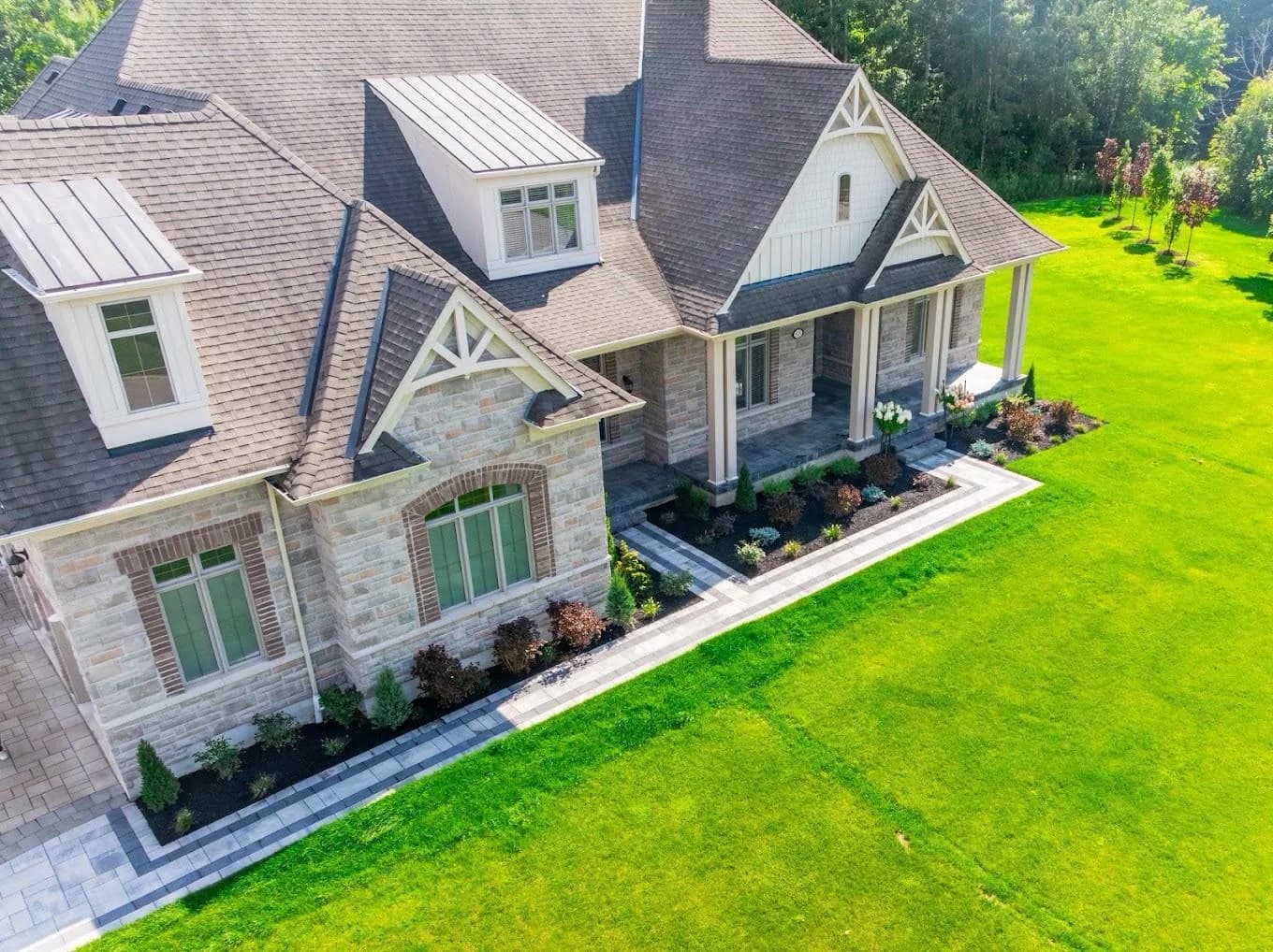 Aerial view of a large home with formal foundation planting and expansive lawn