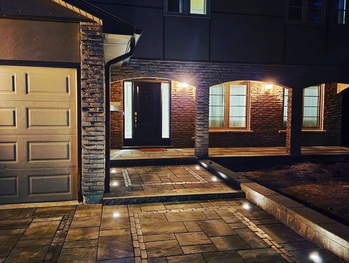 Low-voltage path lighting illuminating a detailed front entrance at night