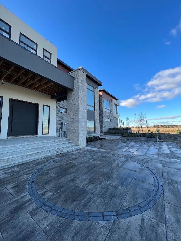 Large-format paver terrace with a circular border beside a contemporary home