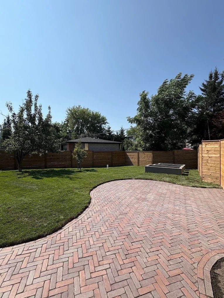 Herringbone paver terrace meeting a broad green lawn