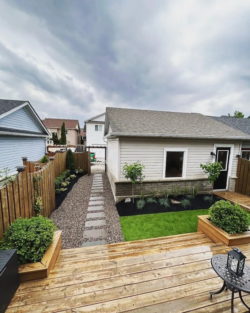 Backyard deck overlooking lawn, gravel paths, and compact planting beds
