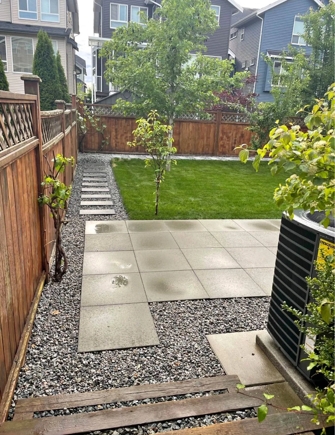 Finished backyard lawn with concrete terrace and gravel stepping path