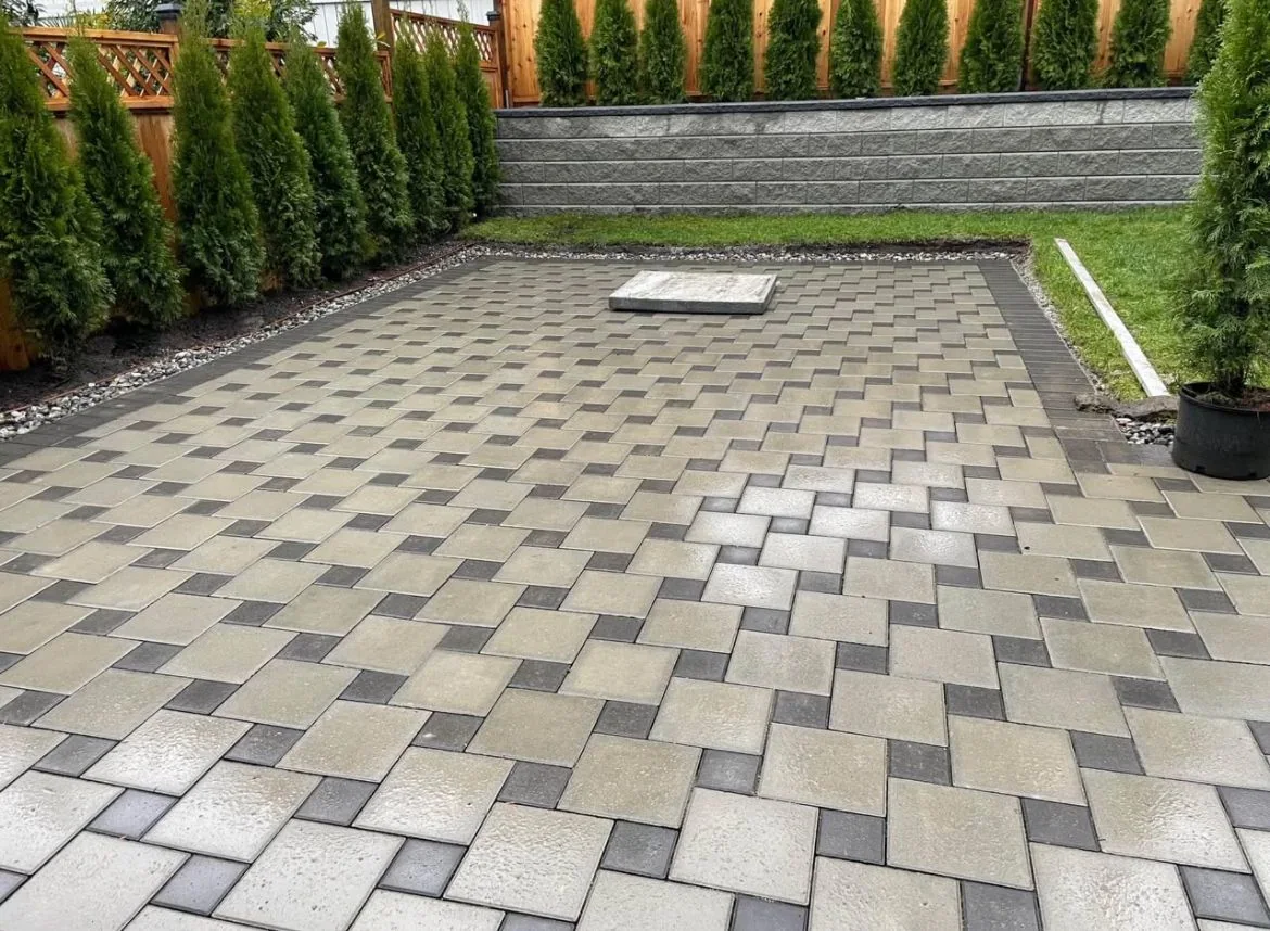 Detailed paver patio with charcoal border and retaining wall