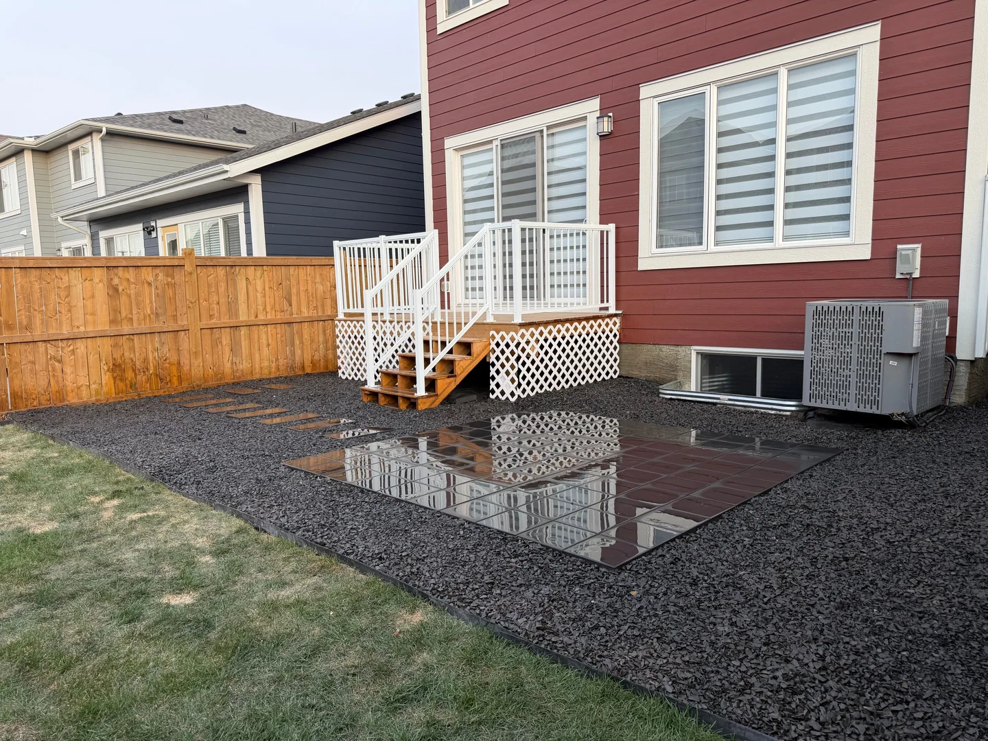 Low-maintenance gravel yard with stepping path and reflective patio tiles