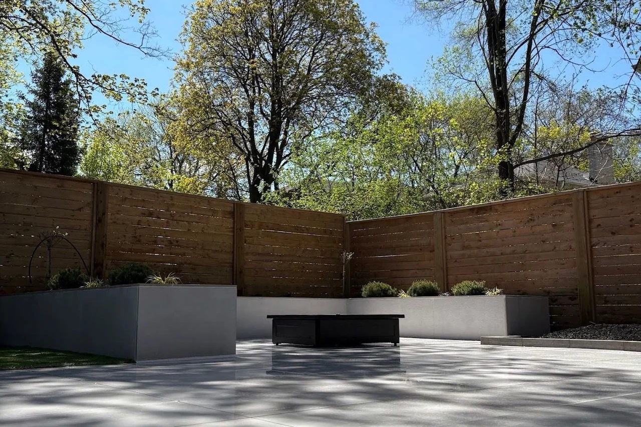 Minimal concrete terrace with integrated planters and horizontal cedar privacy screens