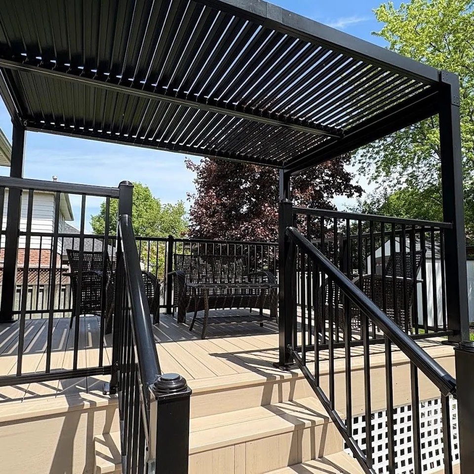 Raised deck and black louvered pergola surrounded by lawn