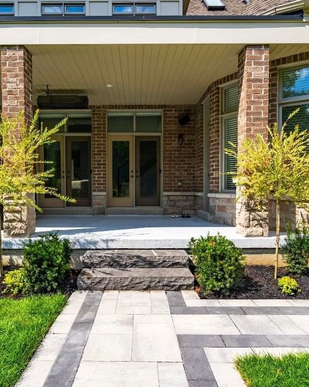 Contemporary front walk with structured shrubs and young trees