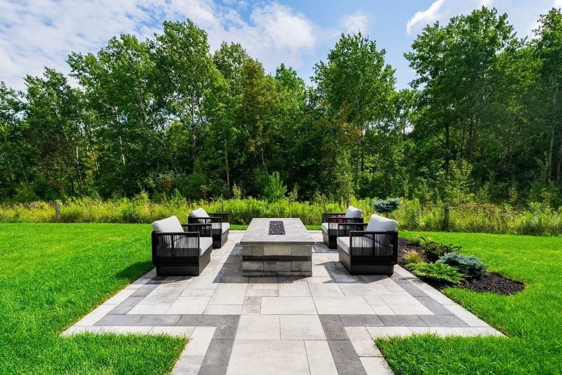 Symmetrical fire-table terrace framed by lawn and woodland