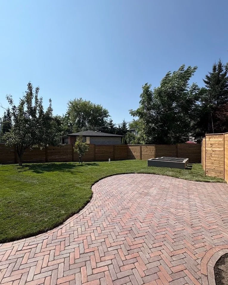 Herringbone paver terrace meeting a broad green lawn