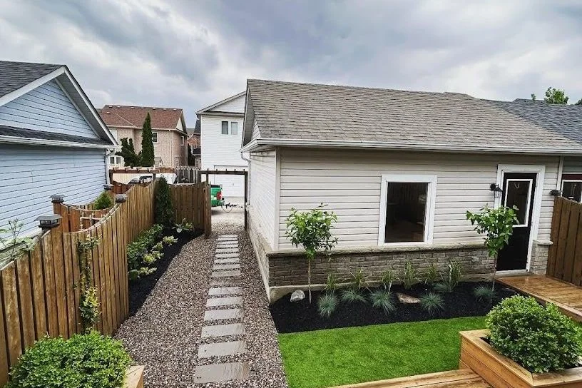 Backyard deck overlooking lawn, gravel paths, and compact planting beds
