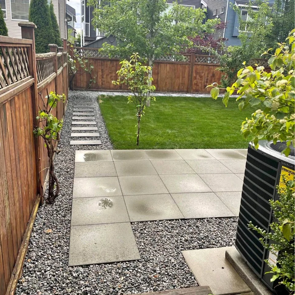 Finished backyard lawn with concrete terrace and gravel stepping path