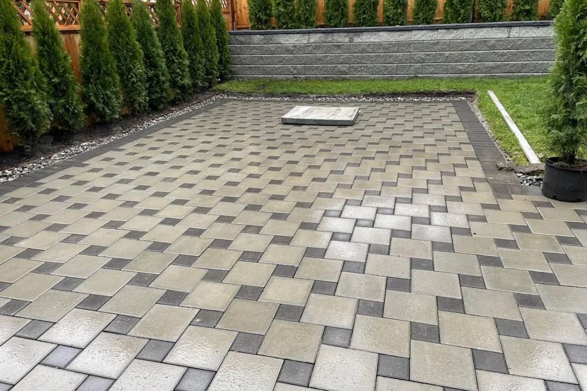 Detailed paver patio with charcoal border and retaining wall