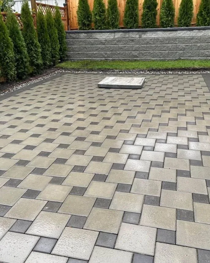 Detailed paver patio with charcoal border and retaining wall