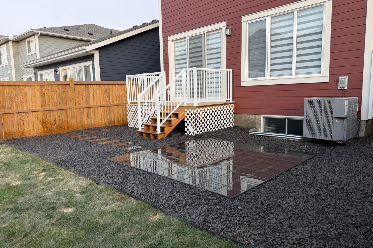 Low-maintenance gravel yard with stepping path and reflective patio tiles