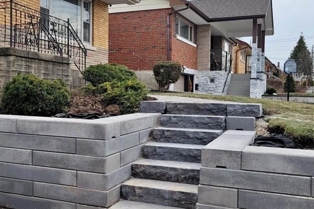 Tiered retaining wall and natural stone steps reshaping a sloped front yard