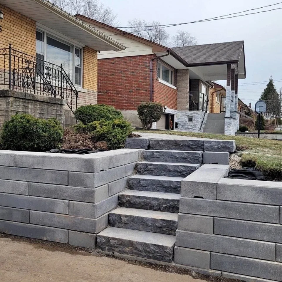 Tiered retaining wall and natural stone steps reshaping a sloped front yard