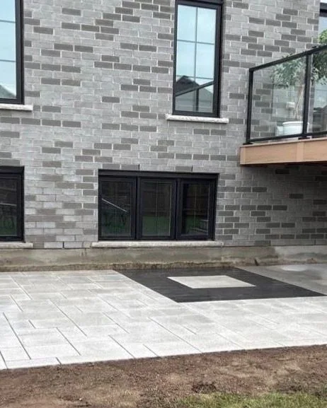 New backyard patio beneath a raised deck during site completion